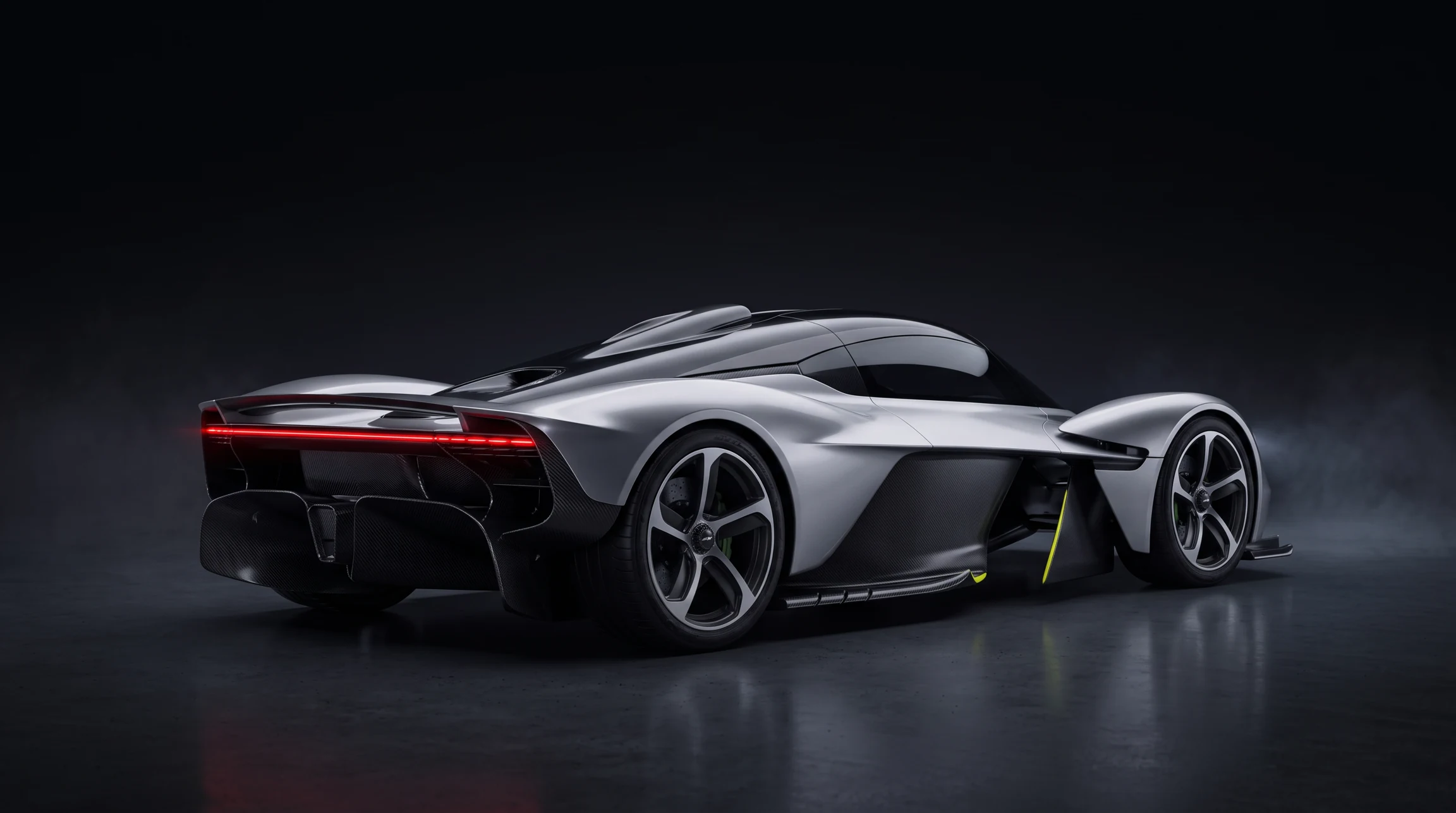 Rear three-quarter view of the titanium supercar, with a slender red taillight and sculpted carbon diffuser